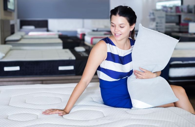 GRFT retail woman sitting on mattress holding a pillow